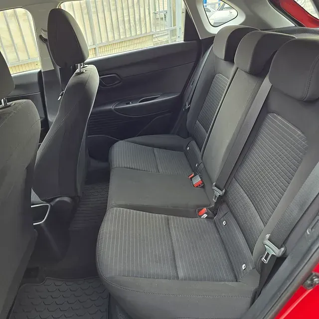 El asiento trasero de un coche rojo con asientos negros