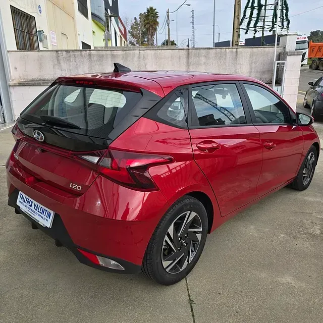 Un coche rojo con matrícula que dice l20