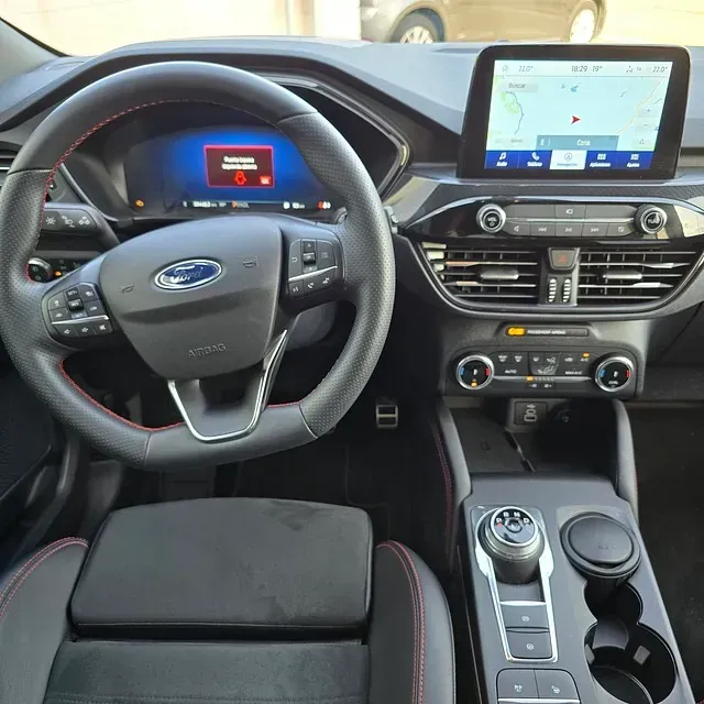 El interior de un coche Ford con volante y tablero.