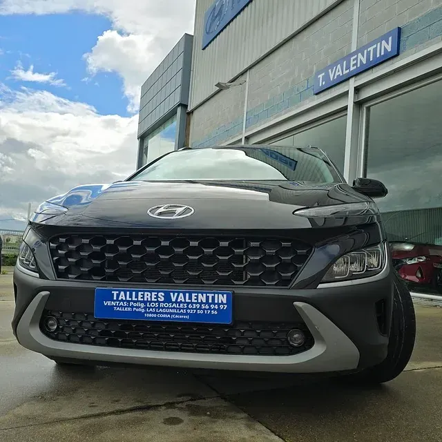 Un coche negro está aparcado delante de Talleres Valentín.