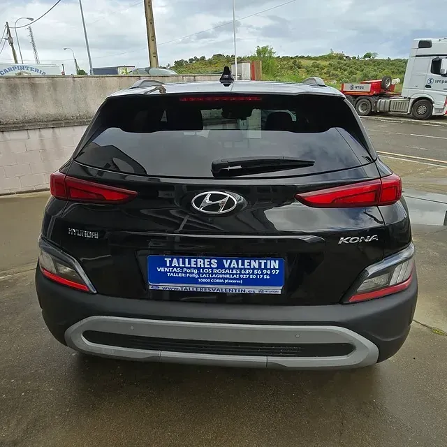 Un coche negro con matrícula azul que dice talleres valentin