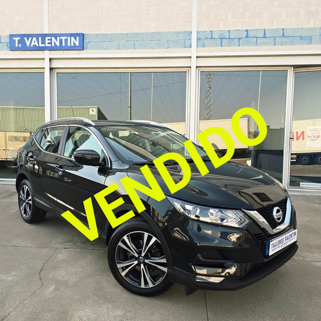 Un Volkswagen Golf está aparcado delante de un concesionario de coches.