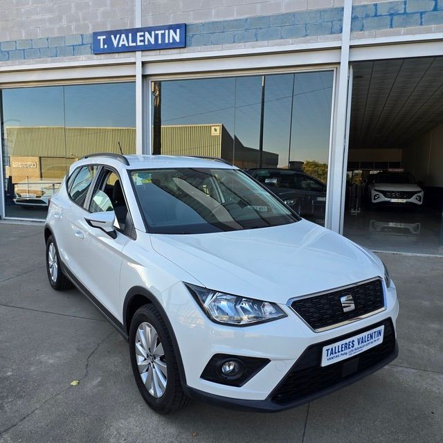Un Audi A3 blanco está estacionado frente a un concesionario de automóviles.