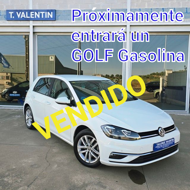 Un coche blanco está aparcado delante de un concesionario de automóviles.