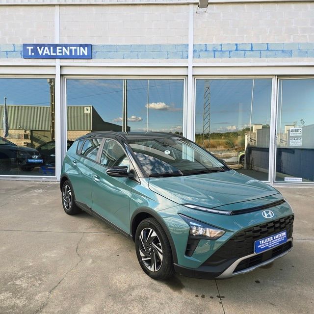 Un coche rojo está aparcado delante de un concesionario de automóviles.