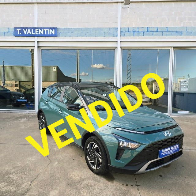 Un coche rojo está aparcado delante de un concesionario de automóviles.