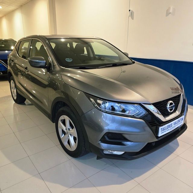 Un Volkswagen Golf está aparcado delante de un concesionario de coches.