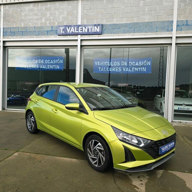 Un coche negro está aparcado delante de un concesionario de automóviles.