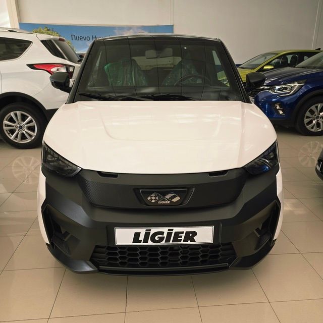 Un Ford Escape plateado está estacionado frente a un concesionario de automóviles.