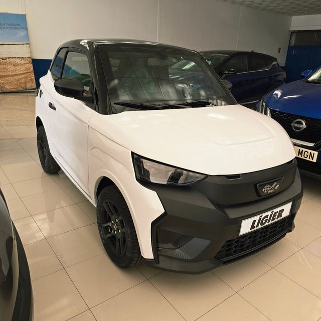 Un Audi A3 blanco está estacionado frente a un concesionario de automóviles.