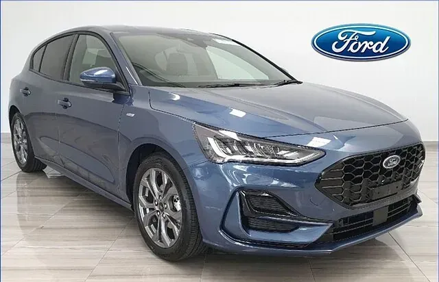 Un Ford Focus hatchback azul está estacionado en una sala de exposición.
