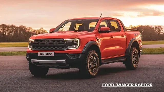 Una camioneta Ford Ranger Raptor roja está estacionada en una carretera.