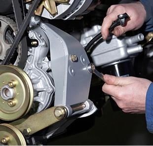 Una persona está trabajando en un motor de motocicleta con una llave inglesa.