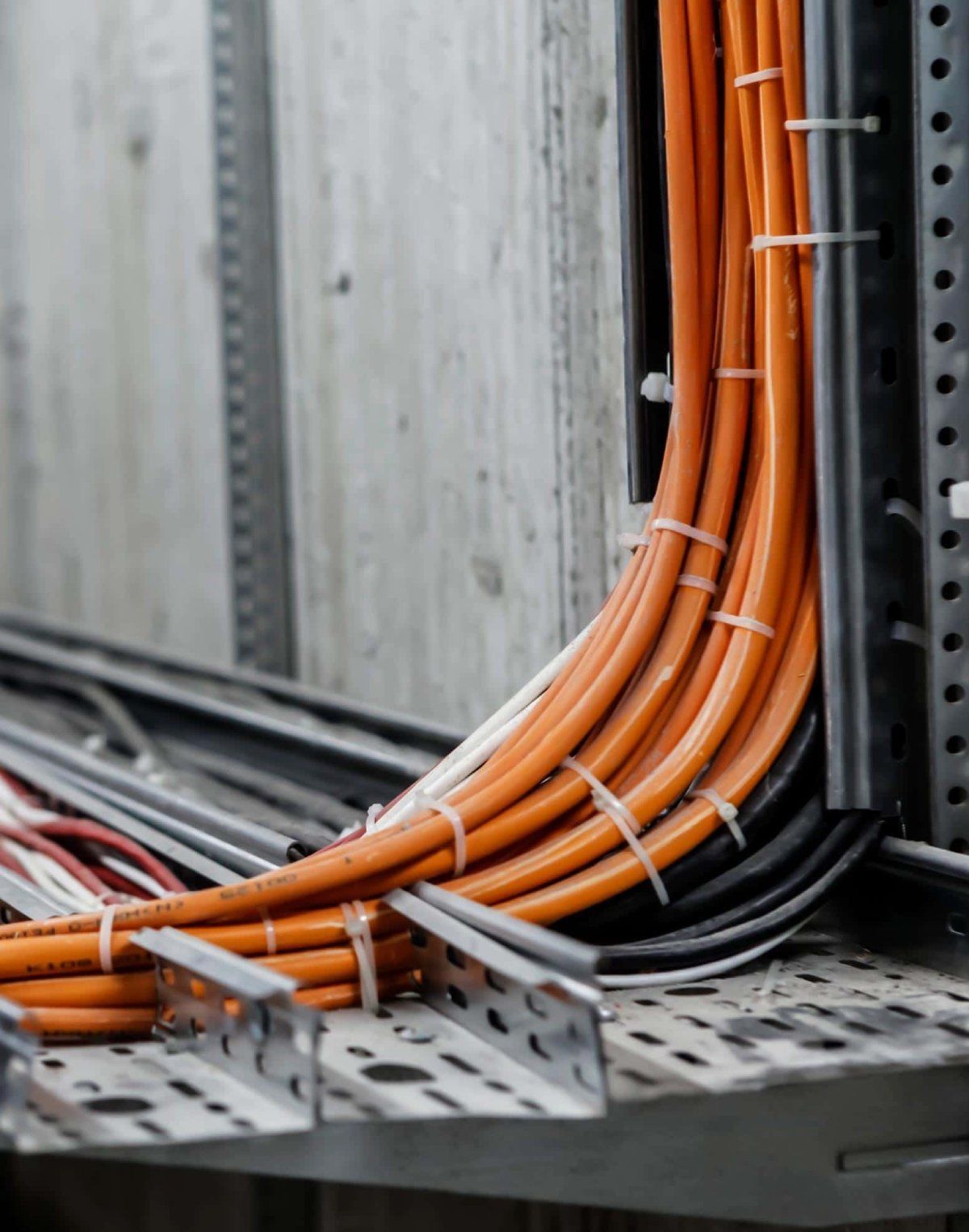 des câbles oranges attachés le long d'un mur