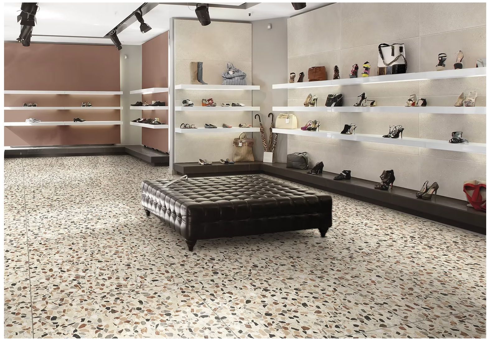 Xclusive - une pièce avec un sol tacheté e, des étagères et un pouf en cuir au centre