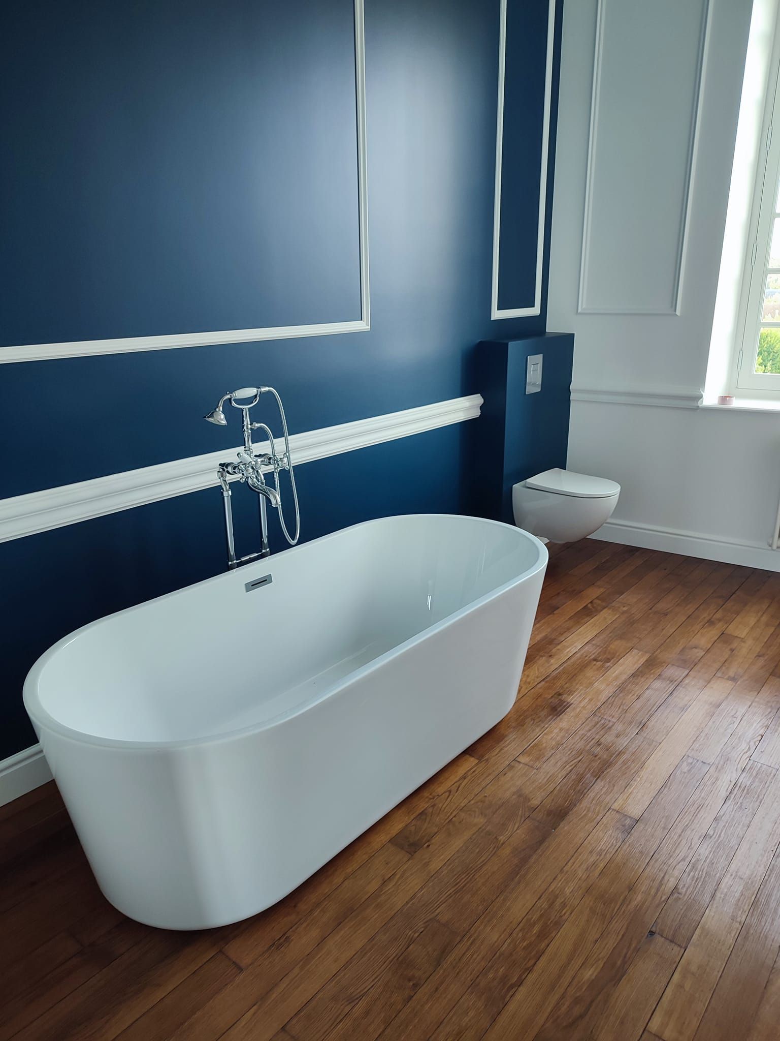 Salle de bain élégante avec murs bleus et moulures