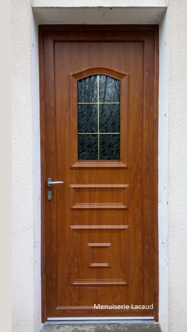 Porte d'entrée en bois avec panneau de verre cintré et poignée argentée, encadrée de pierre blanche.