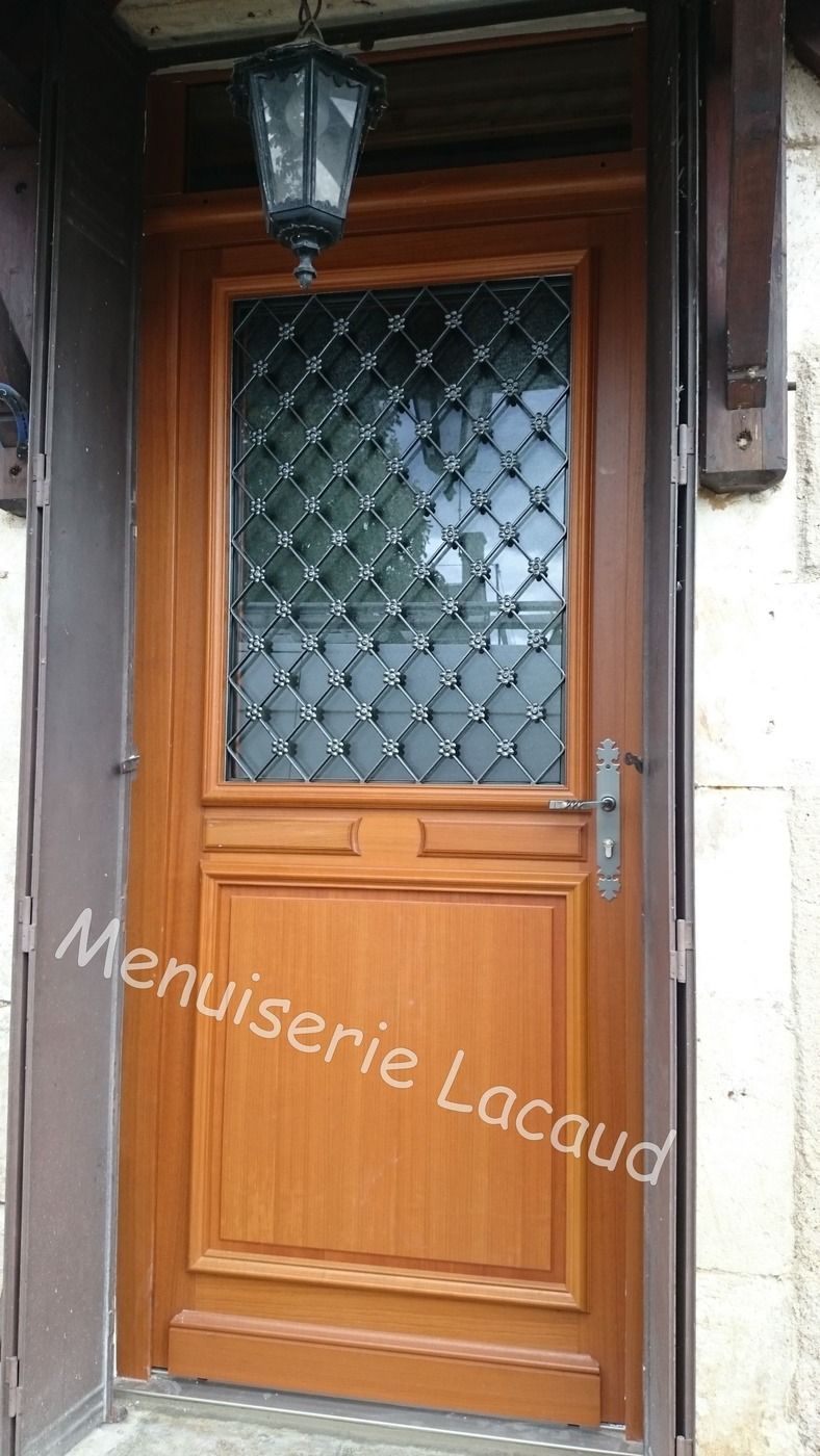 Porte d'entrée en bois avec verre dépoli à motif losanges et une lanterne extérieure au-dessus