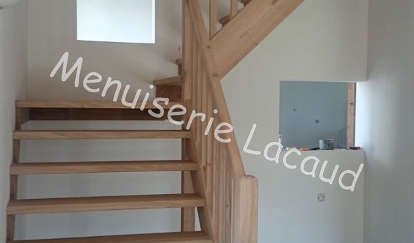 Escalier en bois clair avec contremarches ouvertes et petite niche murale dans un intérieur blanc