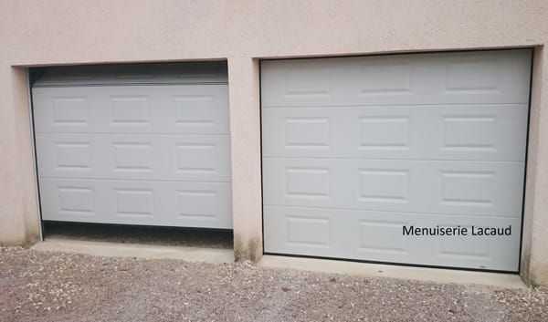 Deux portes de garage grises sur un mur beige, l'une légèrement plus basse que l'autre.