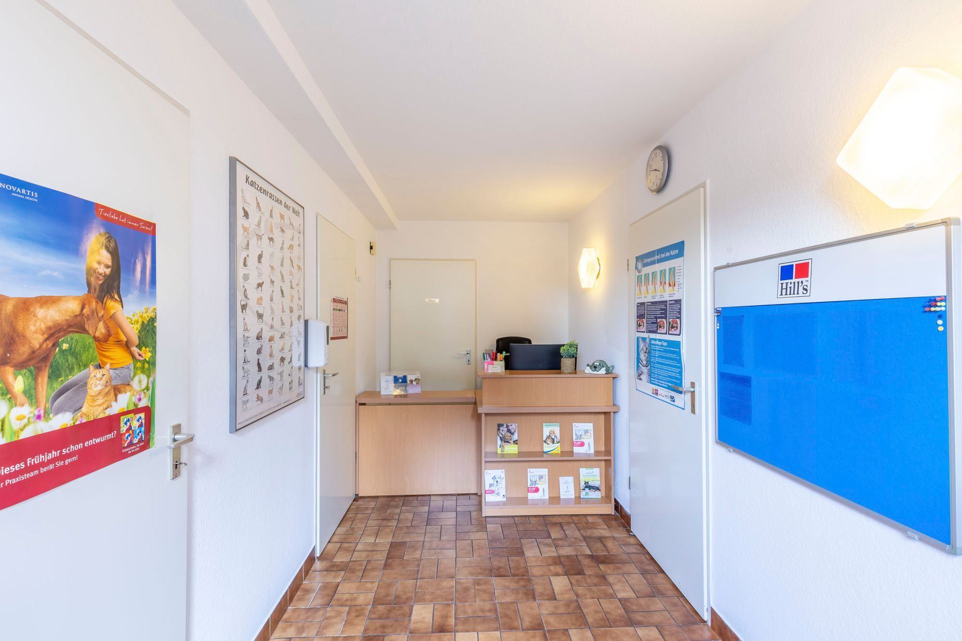 Ein Flur mit einem Schreibtisch und einer blauen Tafel an der Wand.