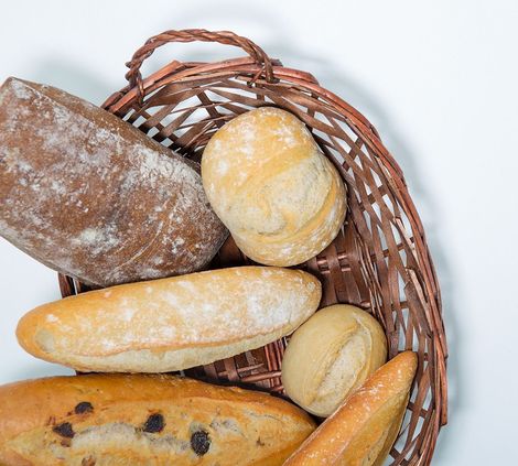 Una cesta de mimbre llena de diferentes tipos de pan