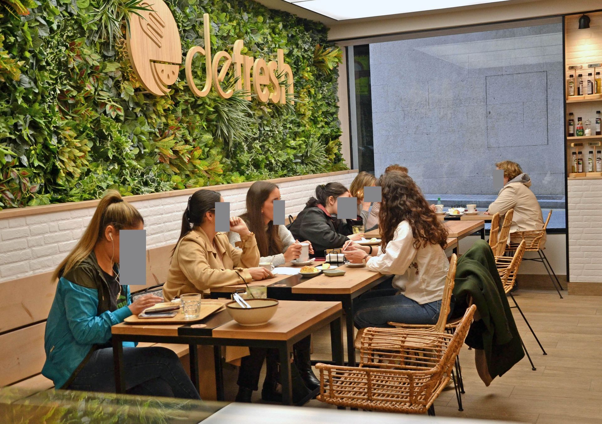 Un grupo de personas están sentadas en mesas en un restaurante.