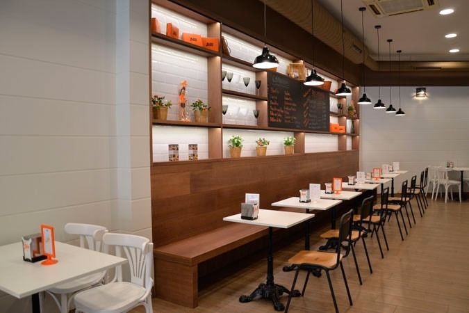 Un restaurante con mesas y sillas y una pizarra en la pared.