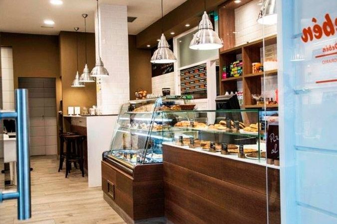 Una panadería con una puerta de cristal y una vitrina llena de comida.