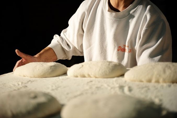 Una persona que lleva una camisa blanca con la palabra pizza escrita en ella.