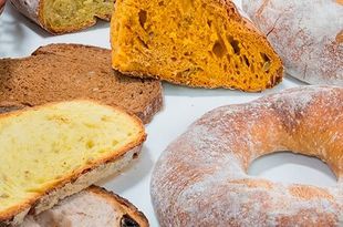 Un montón de diferentes tipos de pan están en un plato blanco