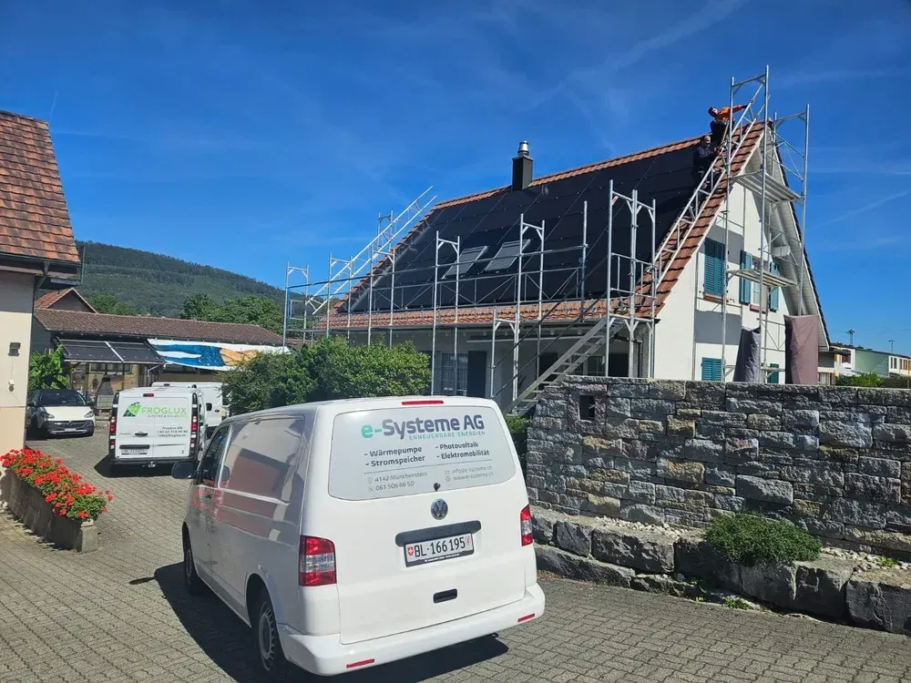 Weisse Lieferwagen parkte, in der Nähe eines Hauses, an dem ein Gerüst aufgebaut und Dacharbeiten durchgeführt wurden.