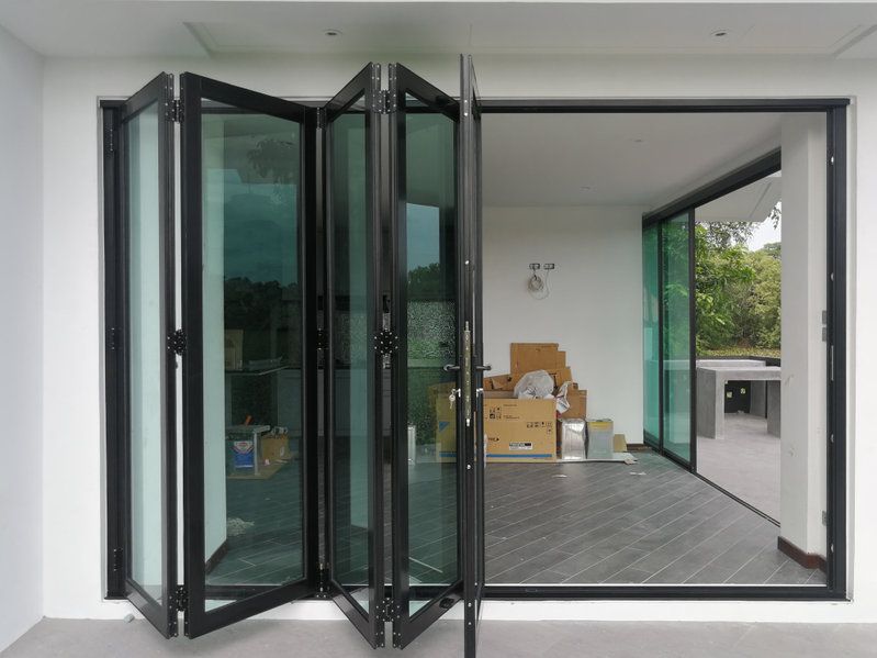 Una habitación con muchas ventanas y cajas en el suelo.