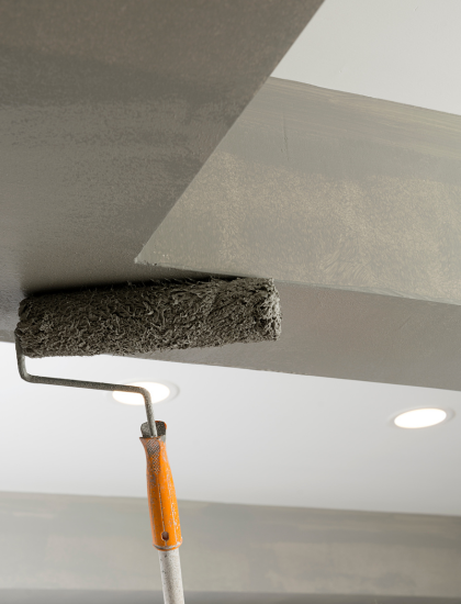 Un rouleau à peinture est utilisé pour peindre un plafond.