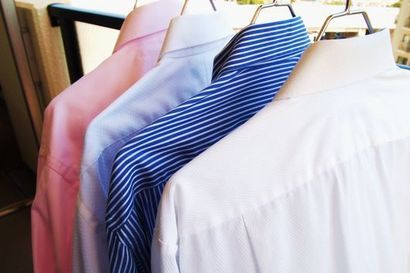 Värillisiä kauluspaitoja henkareissa roikkumassa