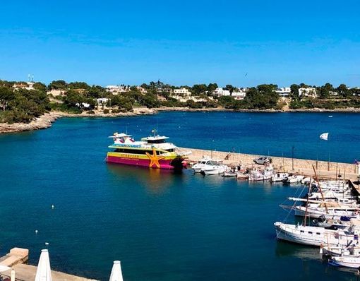 Un barco colorido está atracado en un puerto rodeado de barcos.