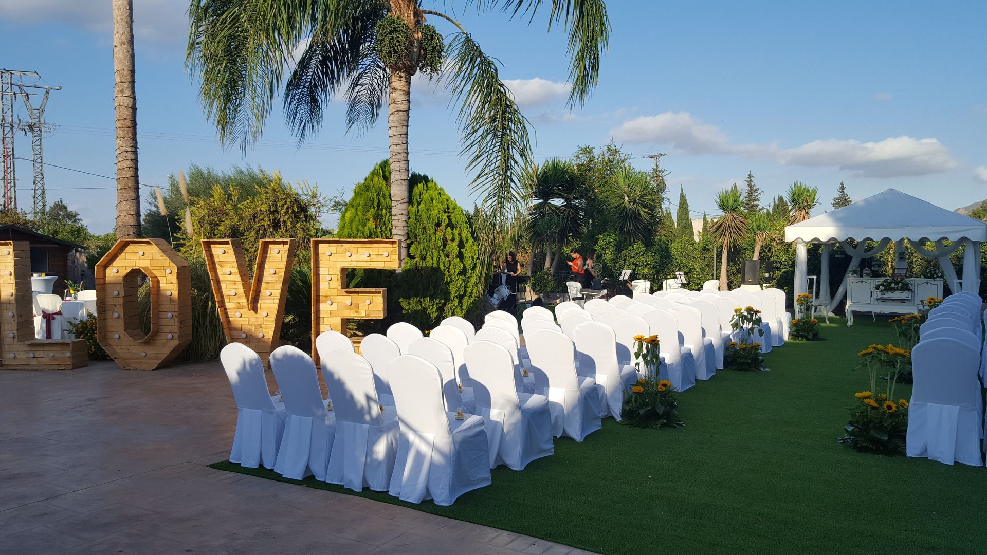 Una fila de sillas blancas están alineadas frente a un signo de amor.