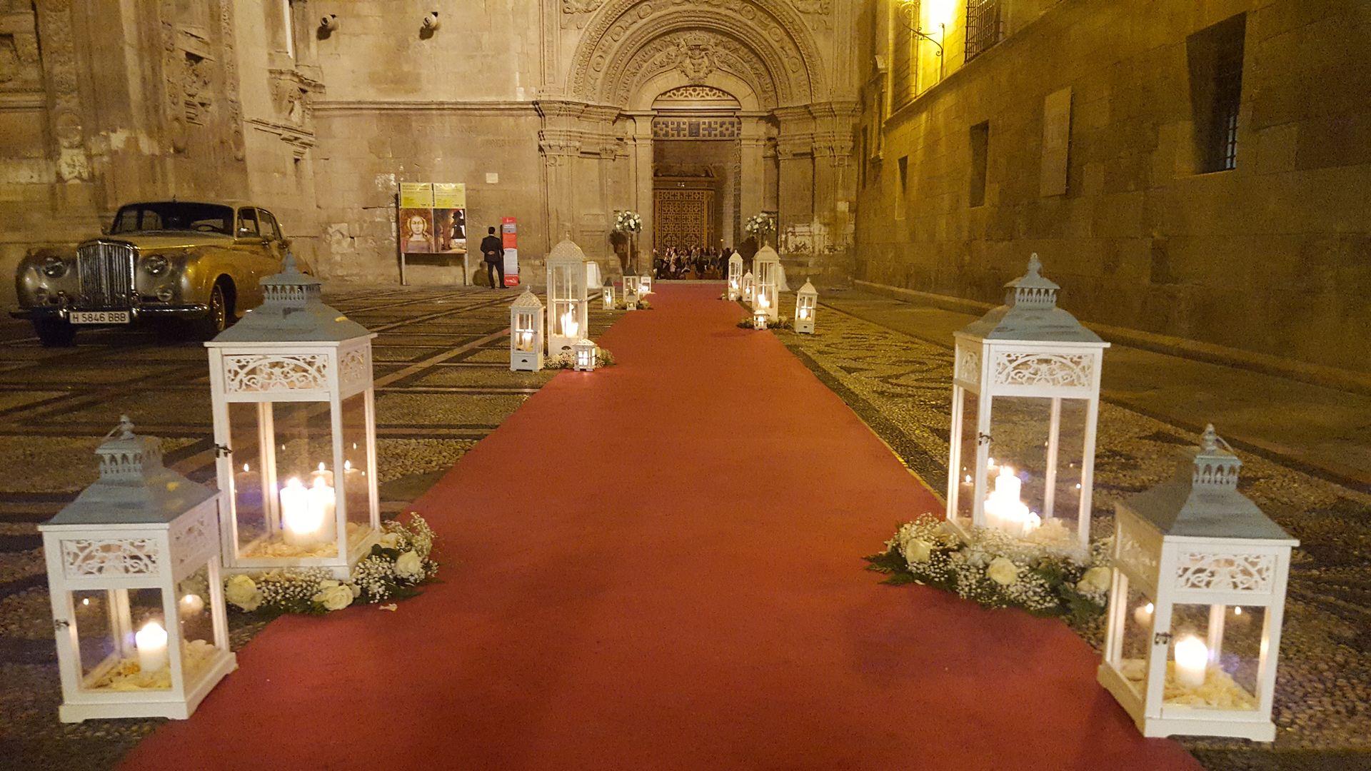 Una alfombra roja con linternas y velas frente a un edificio.