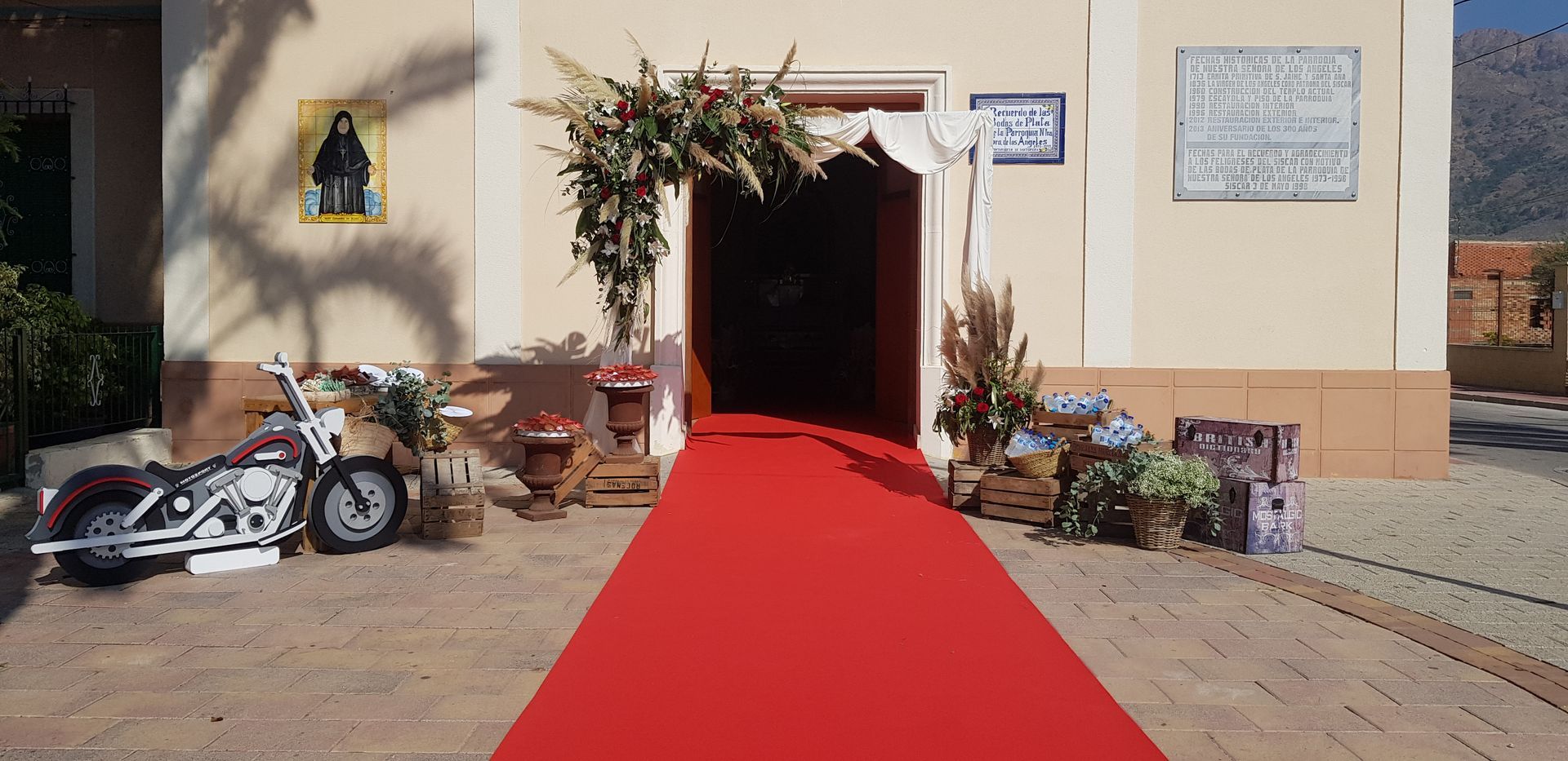 Una alfombra roja conduce a un edificio con una motocicleta estacionada frente a ella.