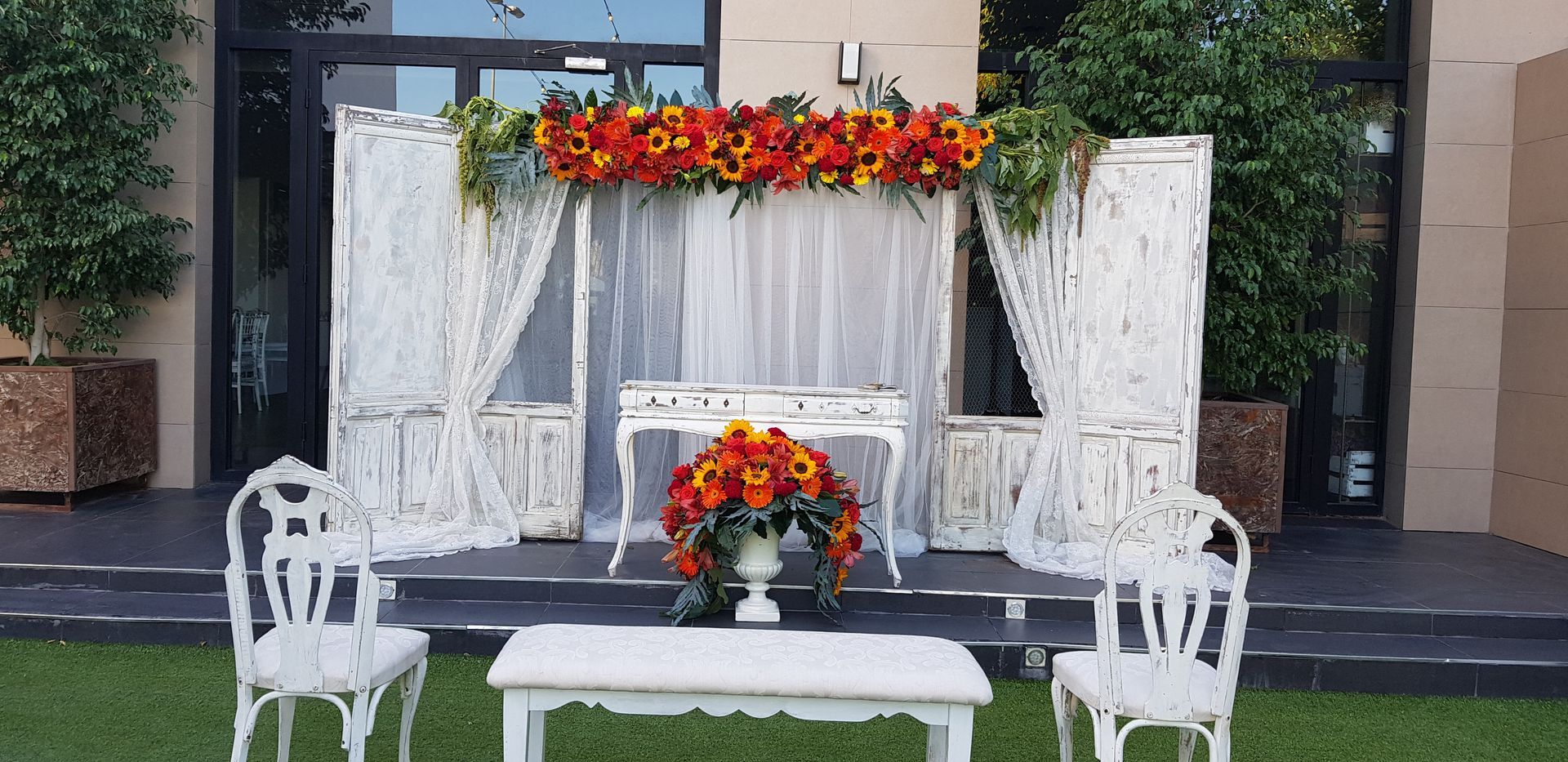 Una mesa y sillas están sentadas frente a un edificio decorado con flores.