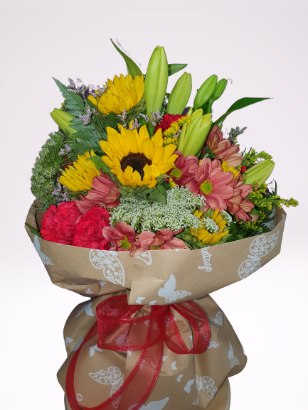 Un ramo de flores envuelto en papel marrón y atado con una cinta roja.