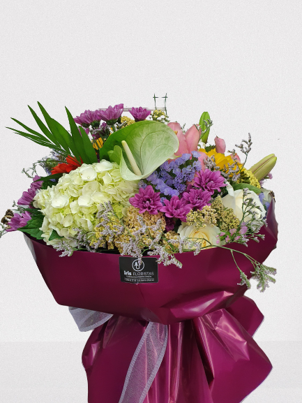 Un gran ramo de flores envuelto en papel morado.