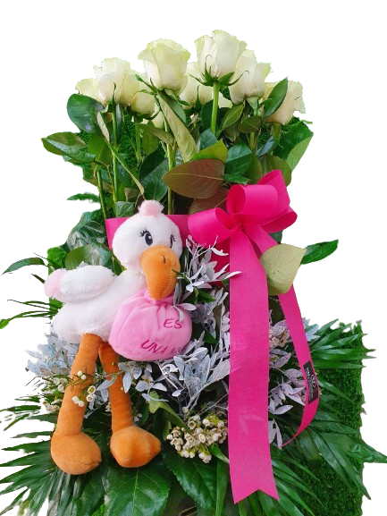Una cigüeña de peluche está sentada en un ramo de flores.