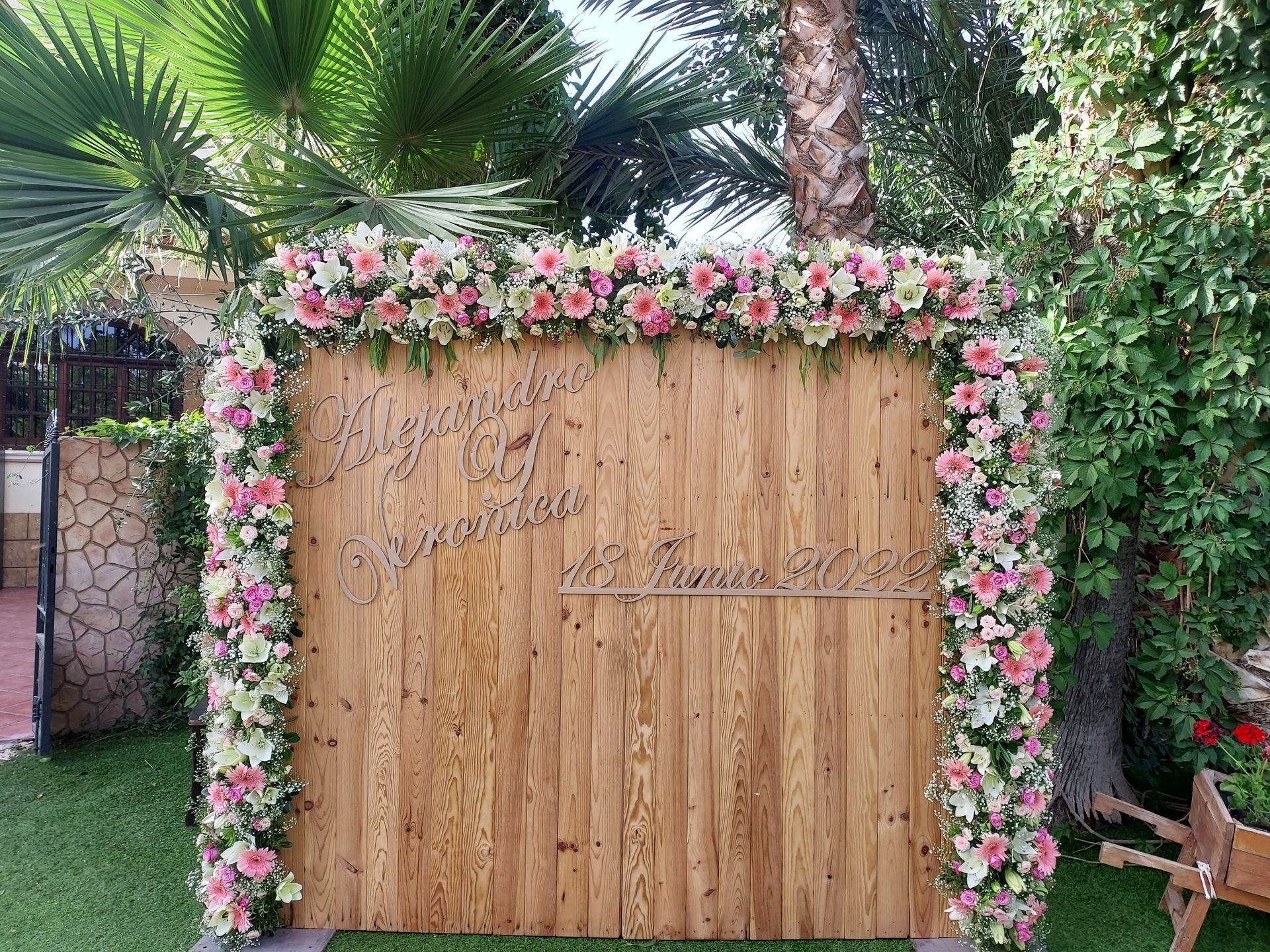 Una pared de madera está decorada con flores rosas y blancas.