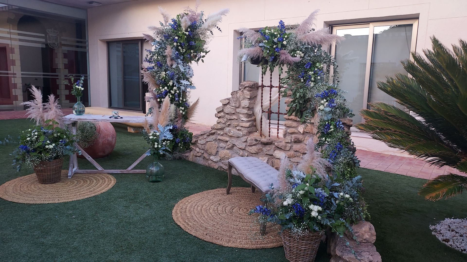 Un jardín con flores y una mesa delante de un edificio.