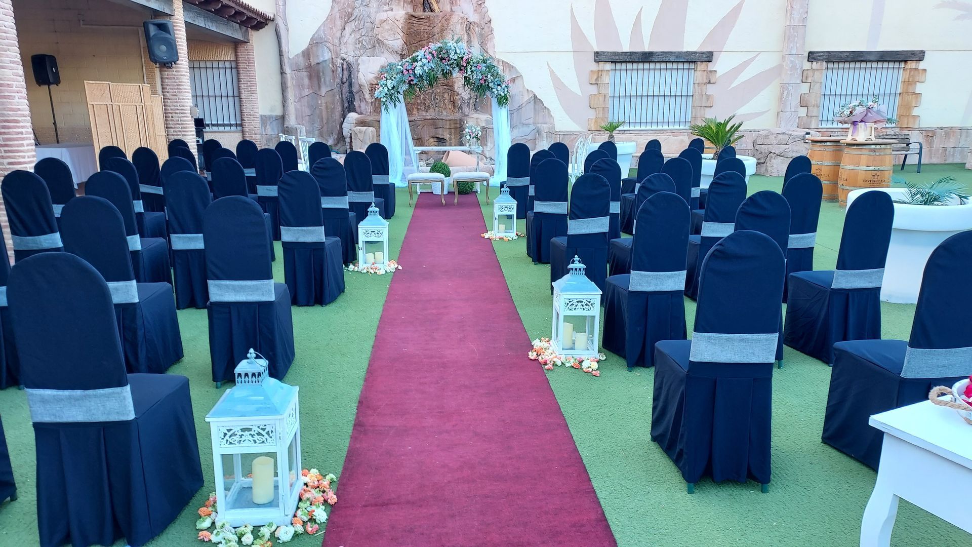 Una fila de sillas alineadas en una fila con una alfombra roja que conduce a una ceremonia de boda.