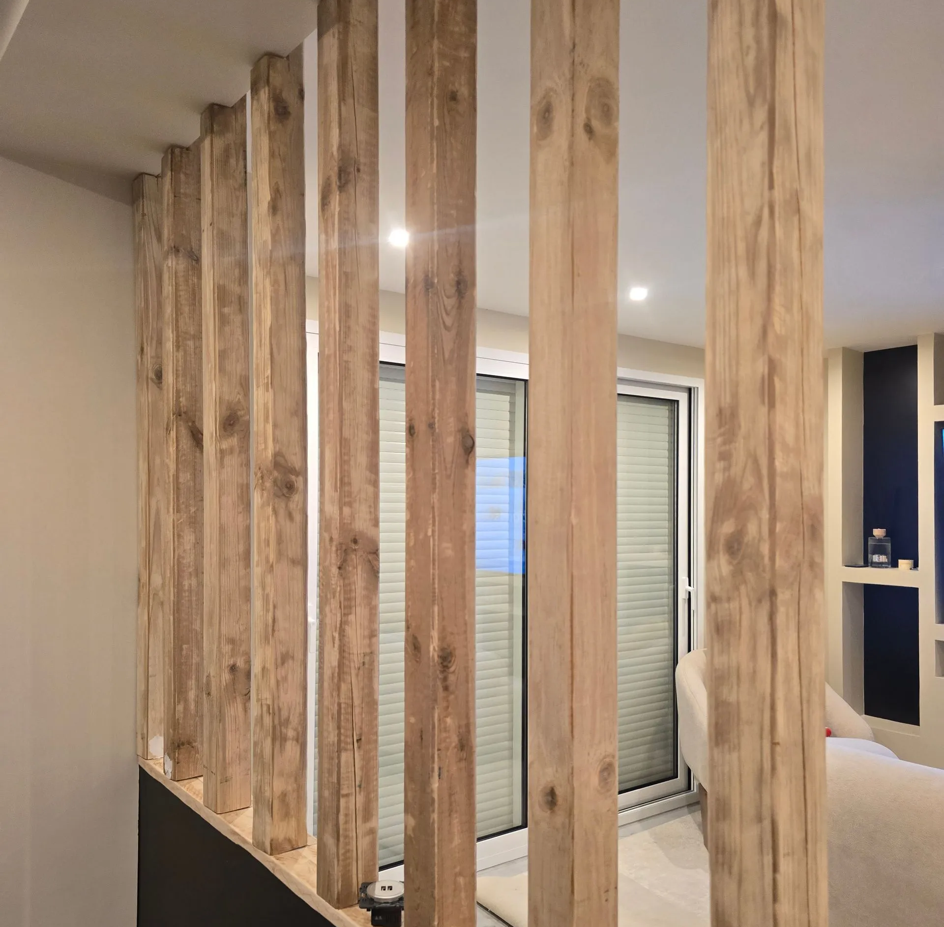 Cloison de séparation en poutre de bois dans un espace de vie moderne.