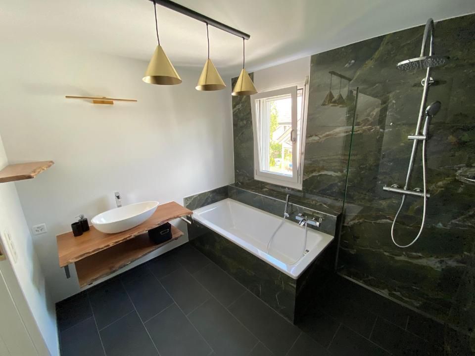 Ein Badezimmer mit Badewanne, Waschbecken und Dusche. Foto von der MS Sanitär Heizung GmbH