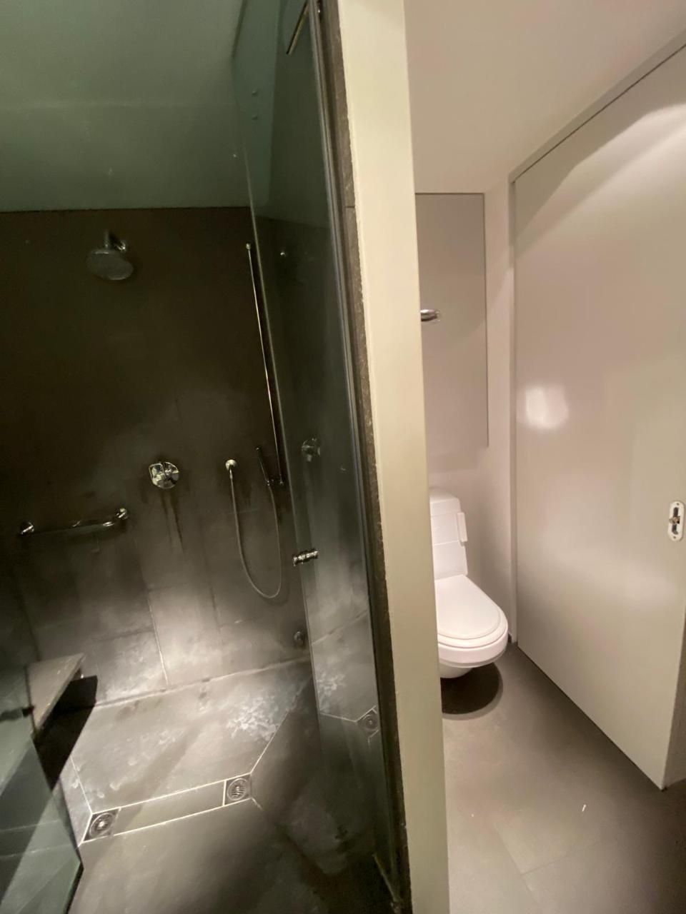 Ein Badezimmer mit Toilette und Dusche mit Glastür. Foto von der MS Sanitär Heizung GmbH