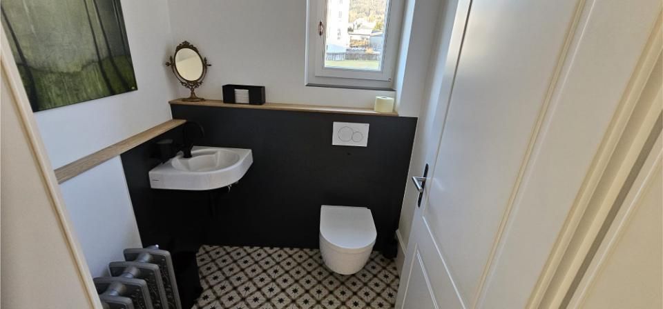 Ein Badezimmer mit Toilette, Waschbecken und Spiegel. Foto von der MS Sanitär Heizung GmbH